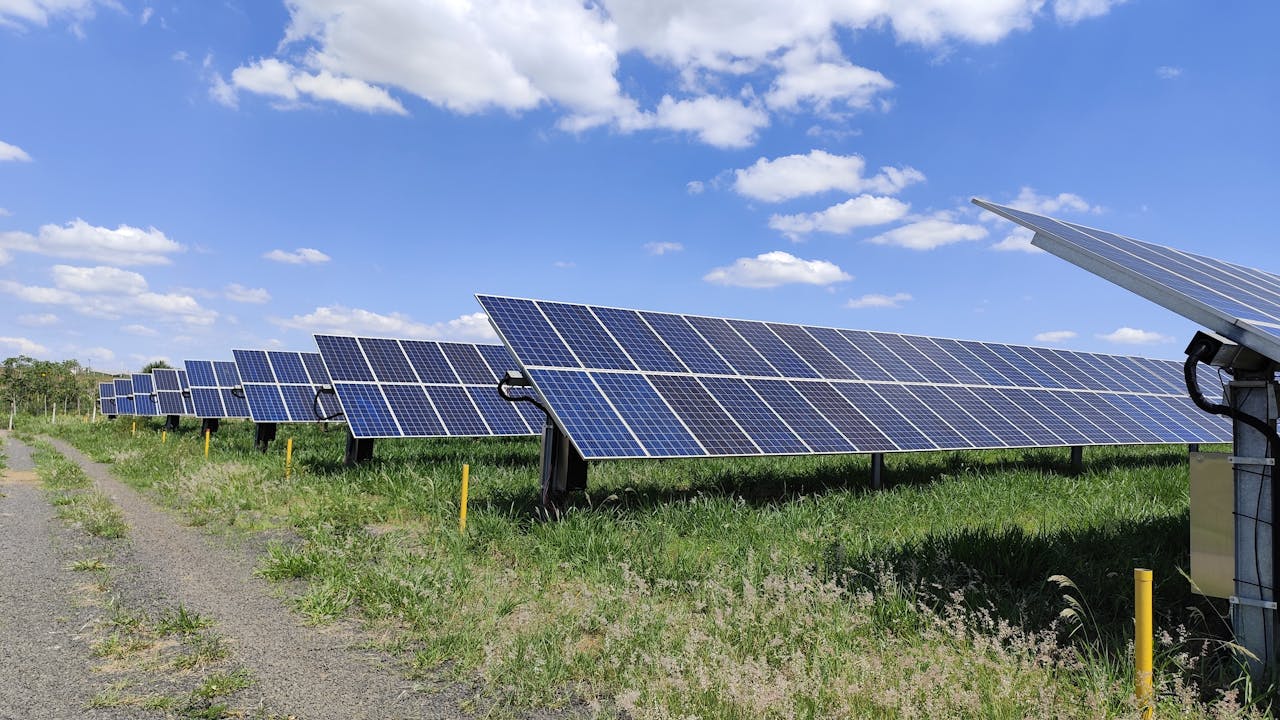 Solar panel array in a field under a bright blue sky in Uberlândia, Brazil. Renewable energy.