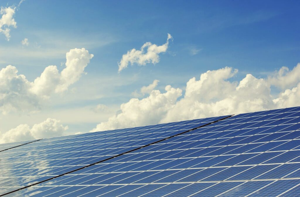 The Art of Drawing Readers In: Your attractive post title goes here Sleek modern solar panels under a vibrant blue sky with clouds, symbolizing clean energy.