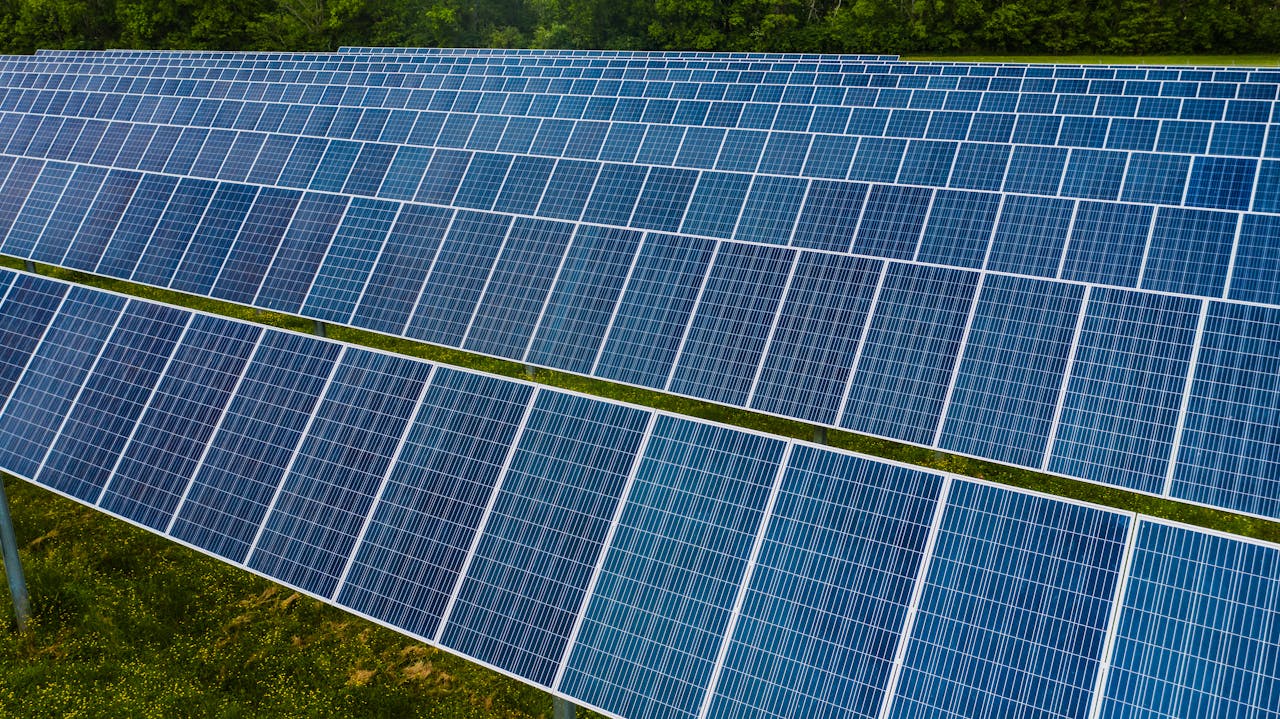 why-choose-us-01 High angle pole mounted solar energy trackers installed on green field in solar power station